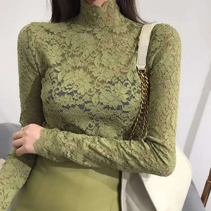 Woman wearing a green lace turtleneck top with long sleeves and floral mesh detailing