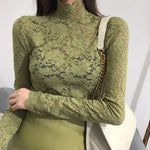 Woman wearing a green lace turtleneck top with long sleeves and floral mesh detailing