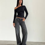 Woman wearing low-rise washed black-grey jeans with straight leg fit and white sneakers