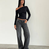 Woman wearing low-rise washed black-grey jeans with straight leg fit and white sneakers