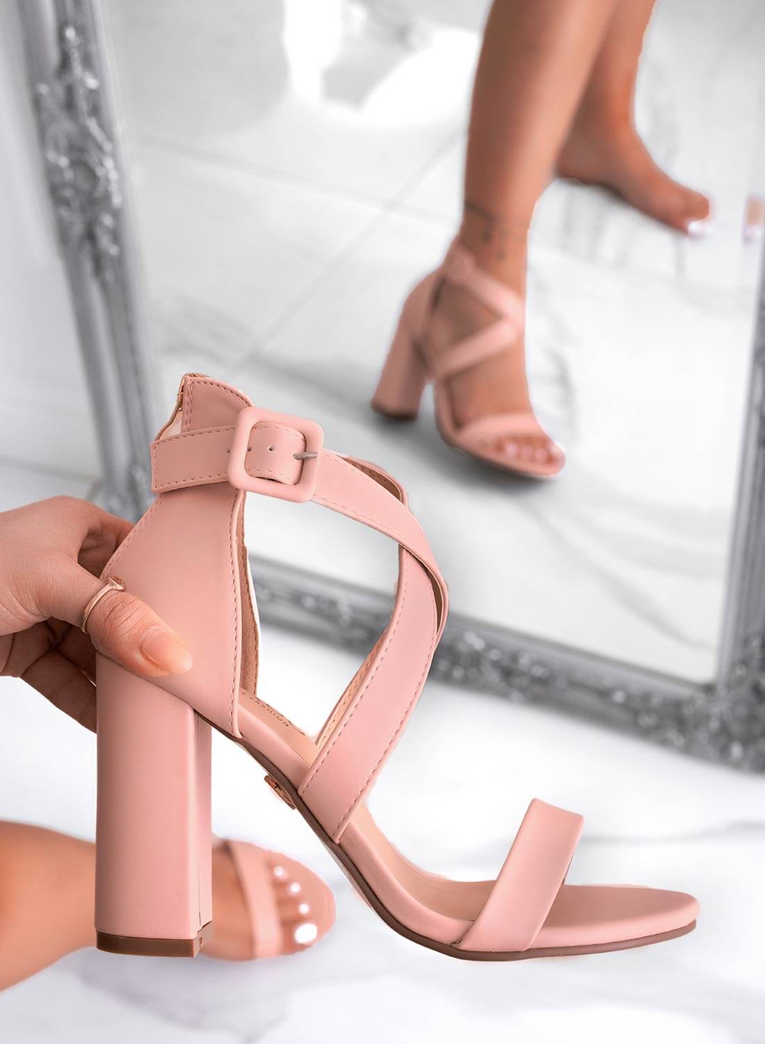 Close-up of woman wearing soft pink cross-strap block heel sandals with ankle buckle23