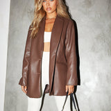 Woman wearing tailored leather-look blazer in chocolate brown with oversized fit and clean lapels