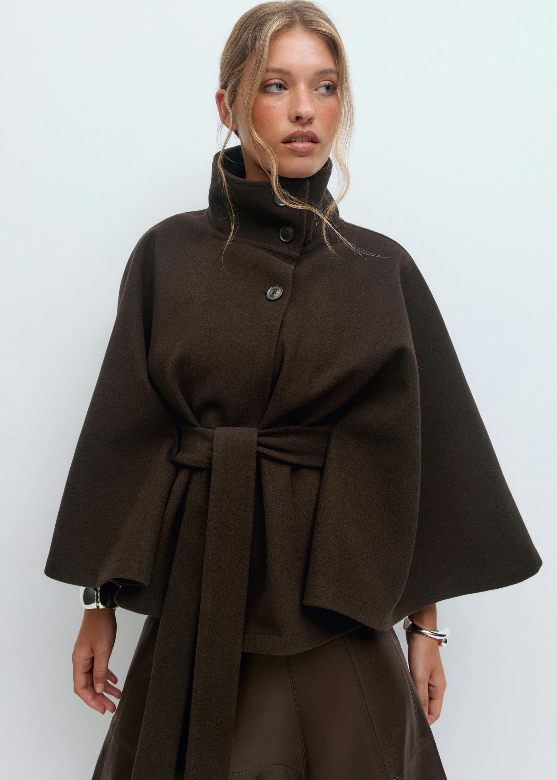 High-neck wool blend cape coat for women with belted waist, available in camel, ivory, navy and espresso brown