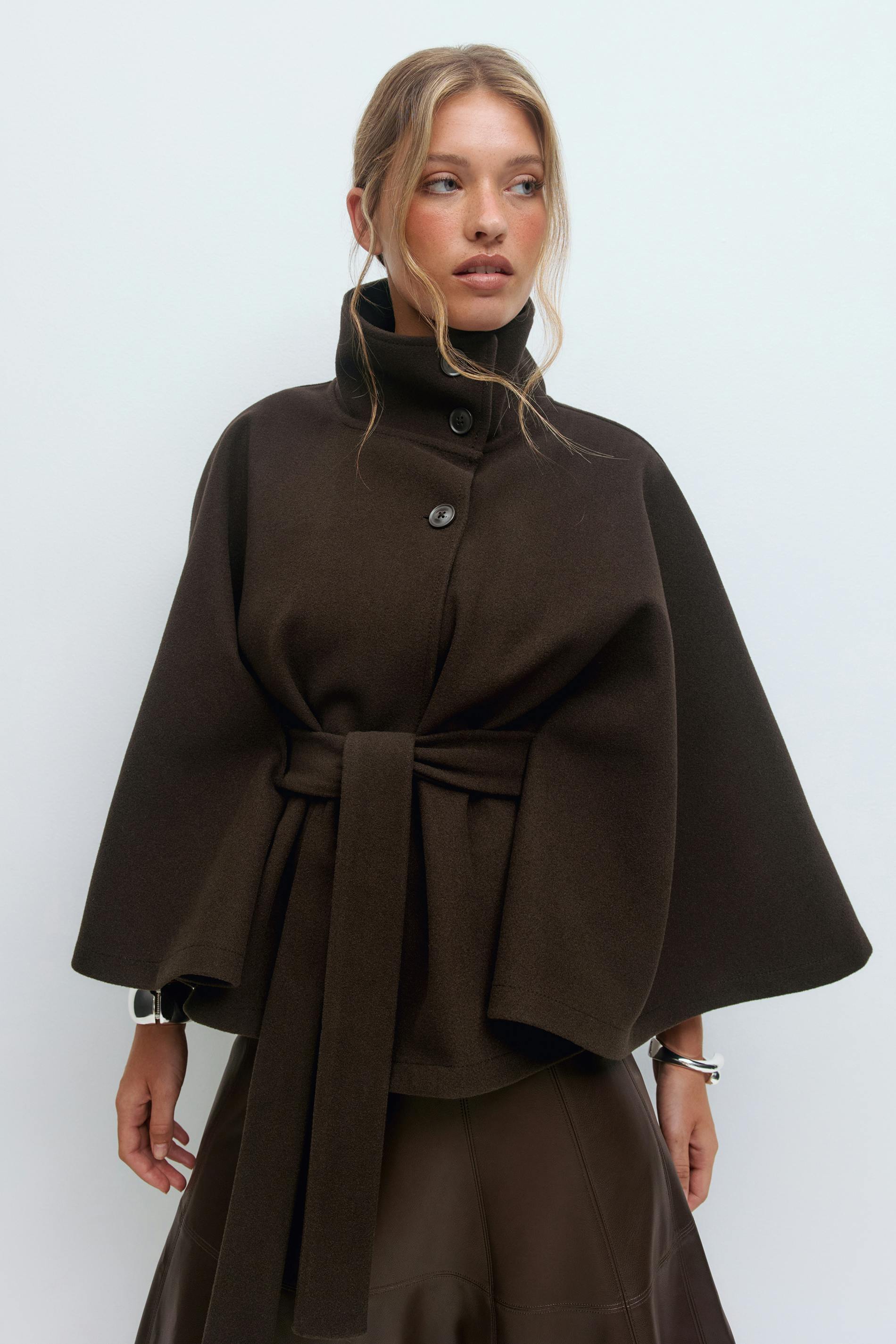 High-neck wool blend cape coat for women with belted waist, available in camel, ivory, navy and espresso brown